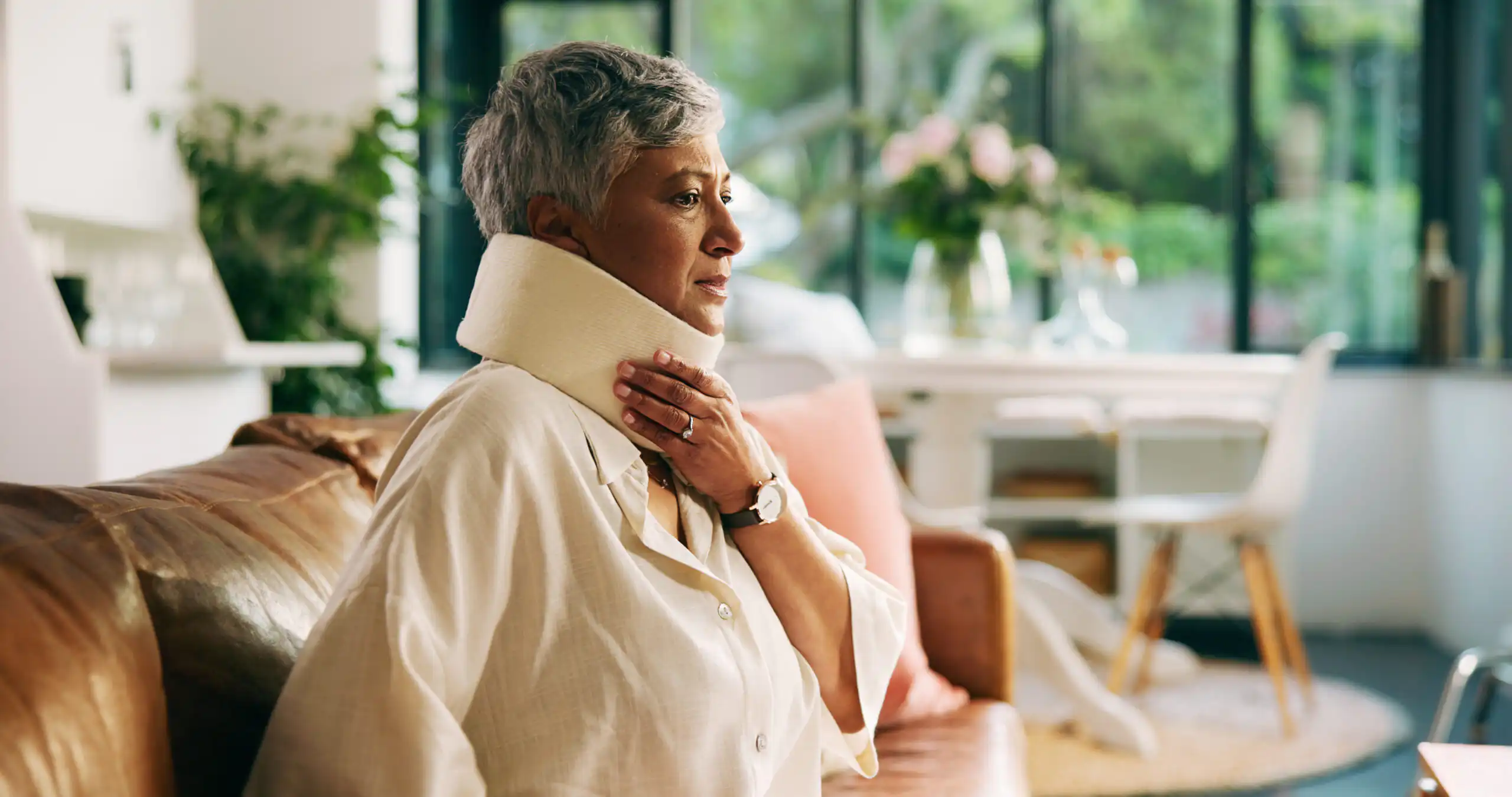 Frau mit Halskrause sitzt nachdenklich auf Sofa