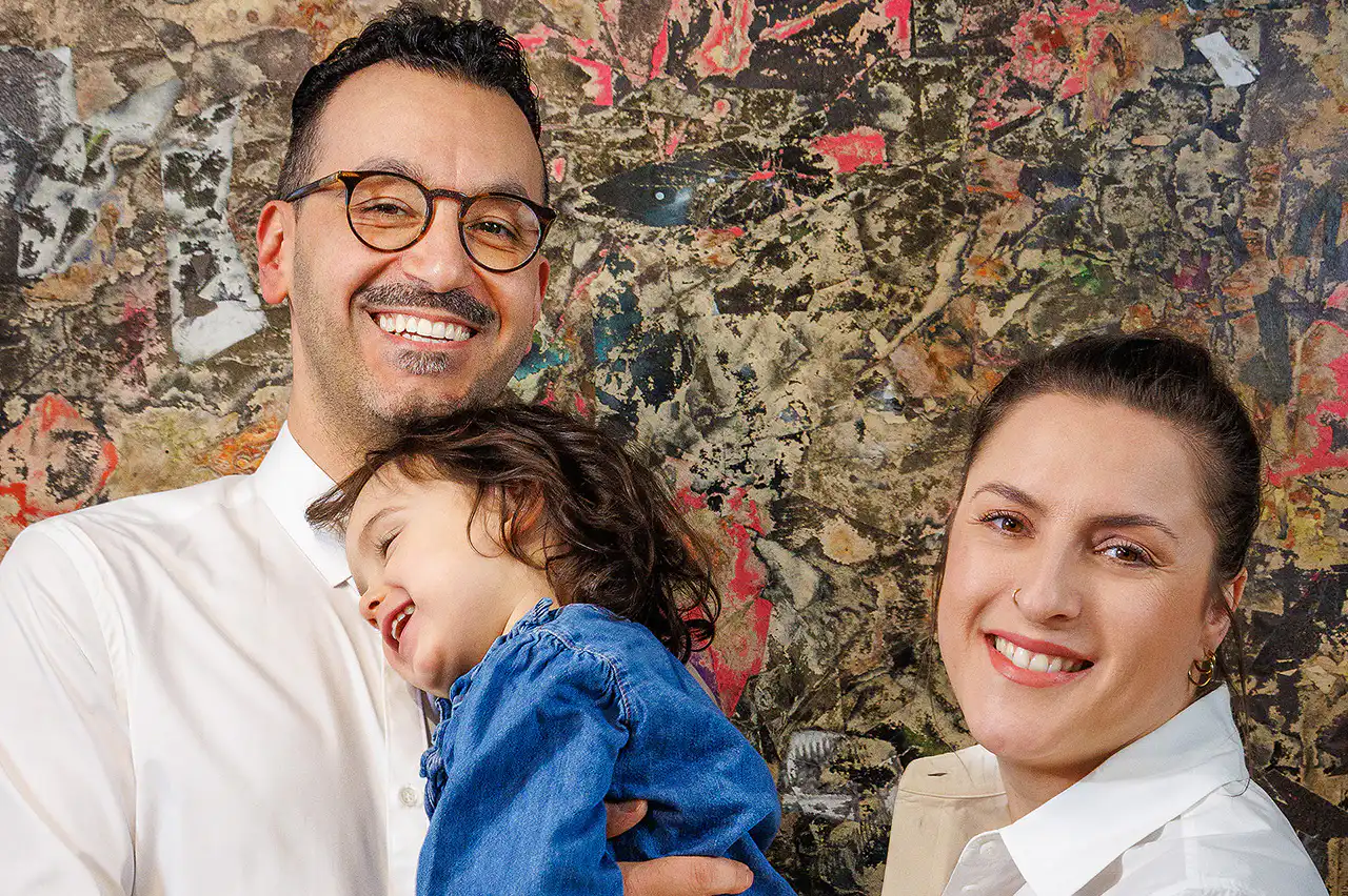 Lächelnde Familie vor abstrakter Kunstwand