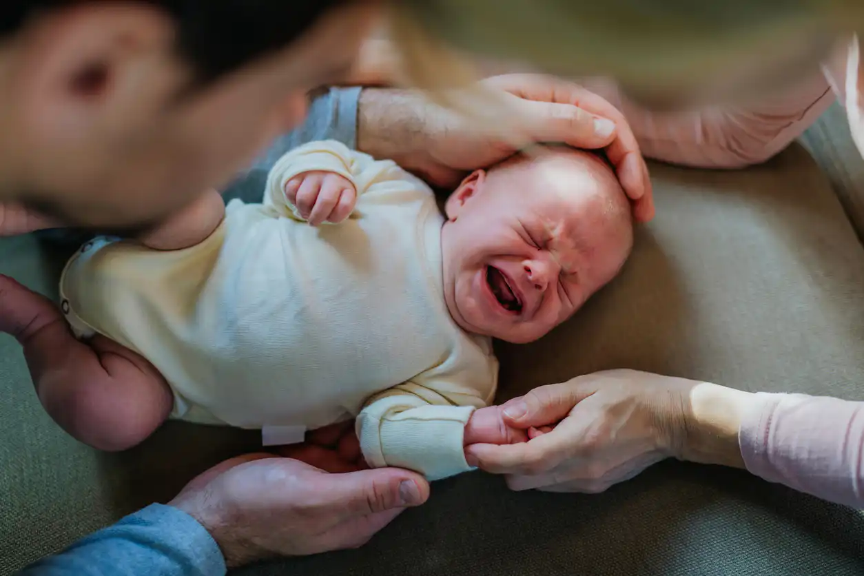 Weinendes Baby wird von Eltern getröstet